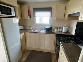 a kitchen with a refrigerator, microwave, and stove at Seaview Caravan Park - Holiday Accommodation 18940 in Ingoldmells