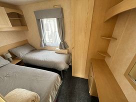a bedroom with two single beds and shelves in Seaview Caravan Park - Holiday Accommodation 18940 in Ingoldmells