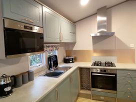 A kitchen with cabinets and appliances at Aberdunant Hall Holiday Park - Holiday Accommodation 19035 Porthmadog