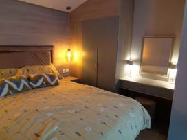 A bedroom with a bed and desk at Aberdunant Hall Holiday Park - Holiday Accommodation 19035, Porthmadog