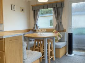 A dining area with a table and stools at Brynowen Holiday Park - Holiday Accommodation 19041 Borth Mis Wales