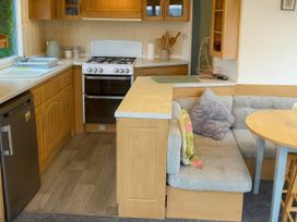 A kitchen with stove and seating area at Brynowen Holiday Park - Holiday Accommodation 19041 Borth Mis Wales