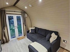 a living room with a gray sectional sofa and glass door at Standen Lodge - Holiday Accommodation 19045, Mablethorpe