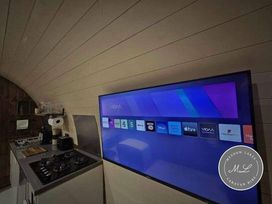 a kitchen with a television displaying app icons at Meadow Lakes Caravan Hire in Mablethorpe