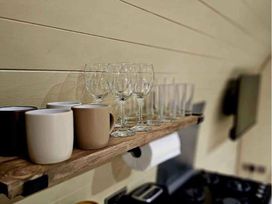 a shelf with mugs and glasses in a kitchen at Standen Lodge - Holiday Accommodation 19045, Mablethorpe