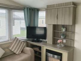 A living room with a sofa, tv, and shelves at Whitehouse Leisure Park - Holiday Accommodation 19055 Towyn, Abergele