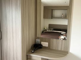 A bedroom with a mirror and hair dryer at Whitehouse Leisure Park - Holiday Accommodation 19055, Towyn, Abergele