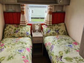 A bedroom with two beds and a nightstand at Whitehouse Leisure Park - Holiday Accommodation 19057, Towyn, Abergele