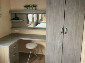 A bedroom with a desk and mirror at Whitehouse Leisure Park - Holiday Accommodation 19057, Towyn, Abergele