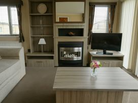 A living room with furniture including a sofa, coffee table, and television at Whitehouse Leisure Park - Holiday Accommodation 19057, Towyn, Abergele