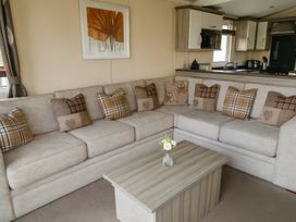 A living room with a sofa, coffee table, and wall art at Whitehouse Leisure Park - Holiday Accommodation 19057, Towyn, Abergele