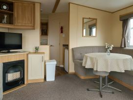 A living room with a television and coffee table at Golden Gate Holiday Centre - Holiday Accommodation 19059 Towyn