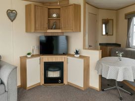 A living room with a television and fireplace at Golden Gate Holiday Centre - Holiday Accommodation 19059 Towyn