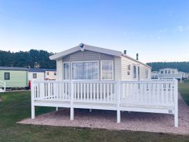a mobile home with a white deck in a park setting at Elie Holiday Park - Holiday Accommodation 19081 Leven