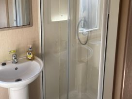 A bathroom with a shower and washbasin at Southview Holiday Park - Holiday Accommodation 19123, Skegness