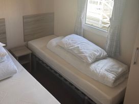 A bedroom with a bed and nightstand at Southview Holiday Park - Holiday Accommodation 19123 in Skegness