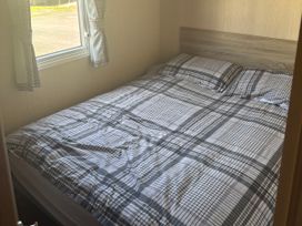 A bedroom with a bed and window at Southview Holiday Park - Holiday Accommodation 19123 Skegness