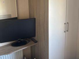 A bedroom with a television and wardrobe at Southview Holiday Park - Holiday Accommodation 19123, Skegness
