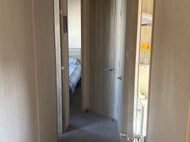 A hallway with doors leading to a bedroom and a shelf at Southview Holiday Park - Holiday Accommodation 19123 Skegness