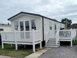 A mobile home with a deck and steps at Hayling Island Holiday Park - Meadow Bay Villages - Holiday Accommodation 19247, Hayling Island