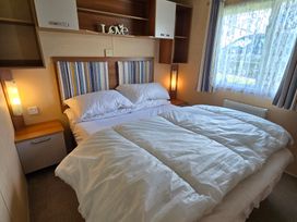 A bedroom with a bed and bedside table at Littlesea Holiday Park - Holiday Accommodation 19270, Weymouth