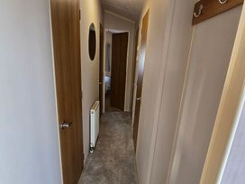 A hallway with doors and a radiator at Littlesea Holiday Park - Holiday Accommodation 19270, Weymouth