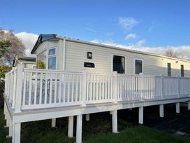 a mobile home with a white deck and multiple windows at Rockley Park - Holiday Accommodation 19386, Poole