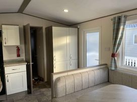 a kitchenette area with a dining table and chairs at Rockley Park - Holiday Accommodation 19386, Poole