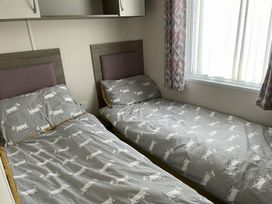 a bedroom with two single beds and patterned bedding at Rockley Park - Holiday Accommodation 19386, Poole