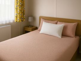 A bedroom with a bed and bedside lamp at Whitley Bay Holiday Park - Holiday Accommodation 19754, Whitley Bay