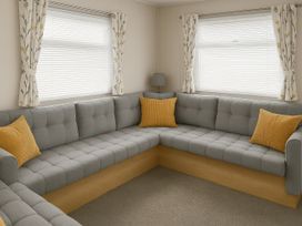 A living room with a gray sectional sofa and cushions at Whitley Bay Holiday Park - Holiday Accommodation 19754, Whitley Bay