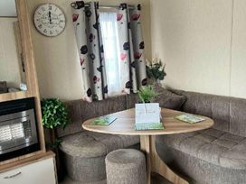 a dining area with a round table and curved seating at Golden Sands Park - Holiday Accommodation 20105 in Ingoldmells, Skegness