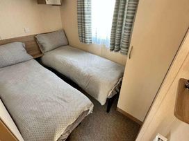 a bedroom with two single beds and a window at Golden Sands Park - Holiday Accommodation 20105 in Ingoldmells, Skegness