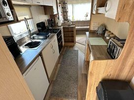 a kitchen area with cabinets, appliances, and counter space at Golden Sands Park - Holiday Accommodation 20105 in Ingoldmells, Skegness