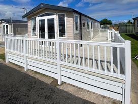 An outdoor area with a holiday home and decking at Marine Holiday Park - Holiday Accommodation 20147, Rhyl