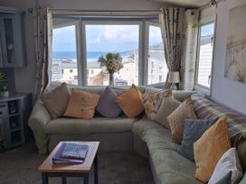 A living room with a sofa and window view at Liskey Hill Caravan Park - Holiday Accommodation 20197 Perranporth