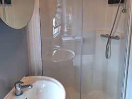 A bathroom with a shower and sink at Liskey Hill Caravan Park - Holiday Accommodation 20197 Perranporth