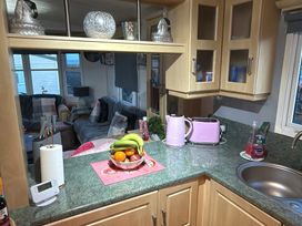 A kitchen with a fruit bowl and kitchen appliances at Red Lion Holiday Park - Holiday Accommodation 20228, Arbroath