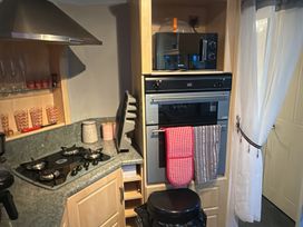 A kitchen with a stove, oven, microwave and sink at Red Lion Holiday Park - Holiday Accommodation 20228 Arbroath