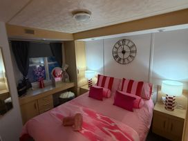 A bedroom with a bed and a dressing table at Red Lion Holiday Park - Holiday Accommodation 20228 Arbroath