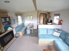 a living room with a sofa, dining area, and kitchen at Perran Sands - Holiday Accommodation 20230 in Perranporth