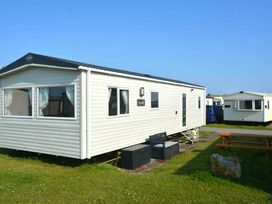 a mobile home with windows and a picnic table outside at Perran Sands - Holiday Accommodation 20230, Perranporth