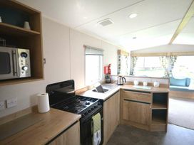 a kitchen with cabinets, a stove, sink, and microwave at Perran Sands - Holiday Accommodation 20230 in Perranporth