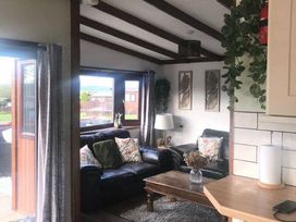 a living room with two sofas and plants at Hafan y Mor Haven - Holiday Accommodation 20258, Pwllheli