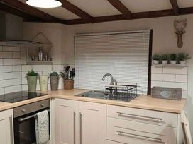 a kitchen with cabinets, sink, and plants on shelves at Hafan y Mor Haven - Holiday Accommodation 20258, Pwllheli