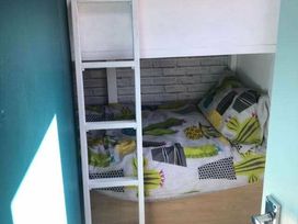 a bunk bed with a lower sleeping area and a ladder at Hafan y Mor Haven - Holiday Accommodation 20258 in Pwllheli