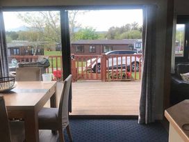 a view from a room showing a deck and cars parked in front at Hafan y Mor Haven - Holiday Accommodation 20258 Pwllheli