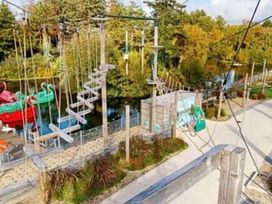 an aerial view of a ropes course and playground with trees and a pond at Hafan y Mor Haven - Holiday Accommodation 20258 in Pwllheli