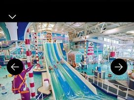 an indoor waterpark with a water slide and children playing at Hafan y Mor Haven - Holiday Accommodation 20258 in Pwllheli