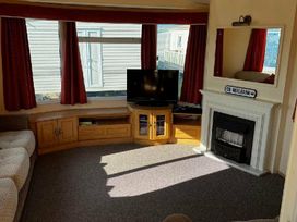 a living room with a television and a fireplace at Bell Bank Caravan Park - Holiday Accommodation 20266 Chapel St Leonards
